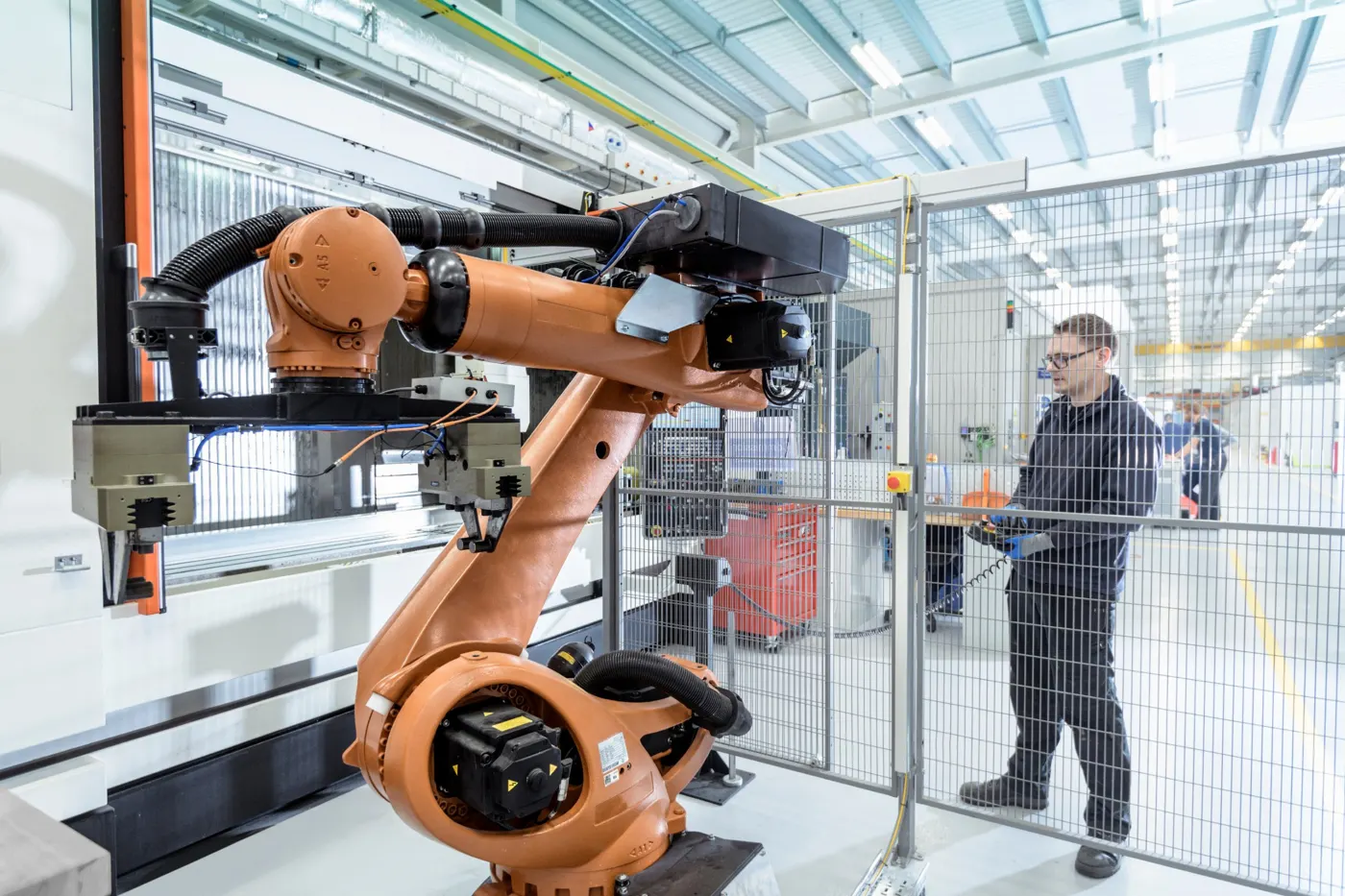 Un ingénieur programme un robot industriel