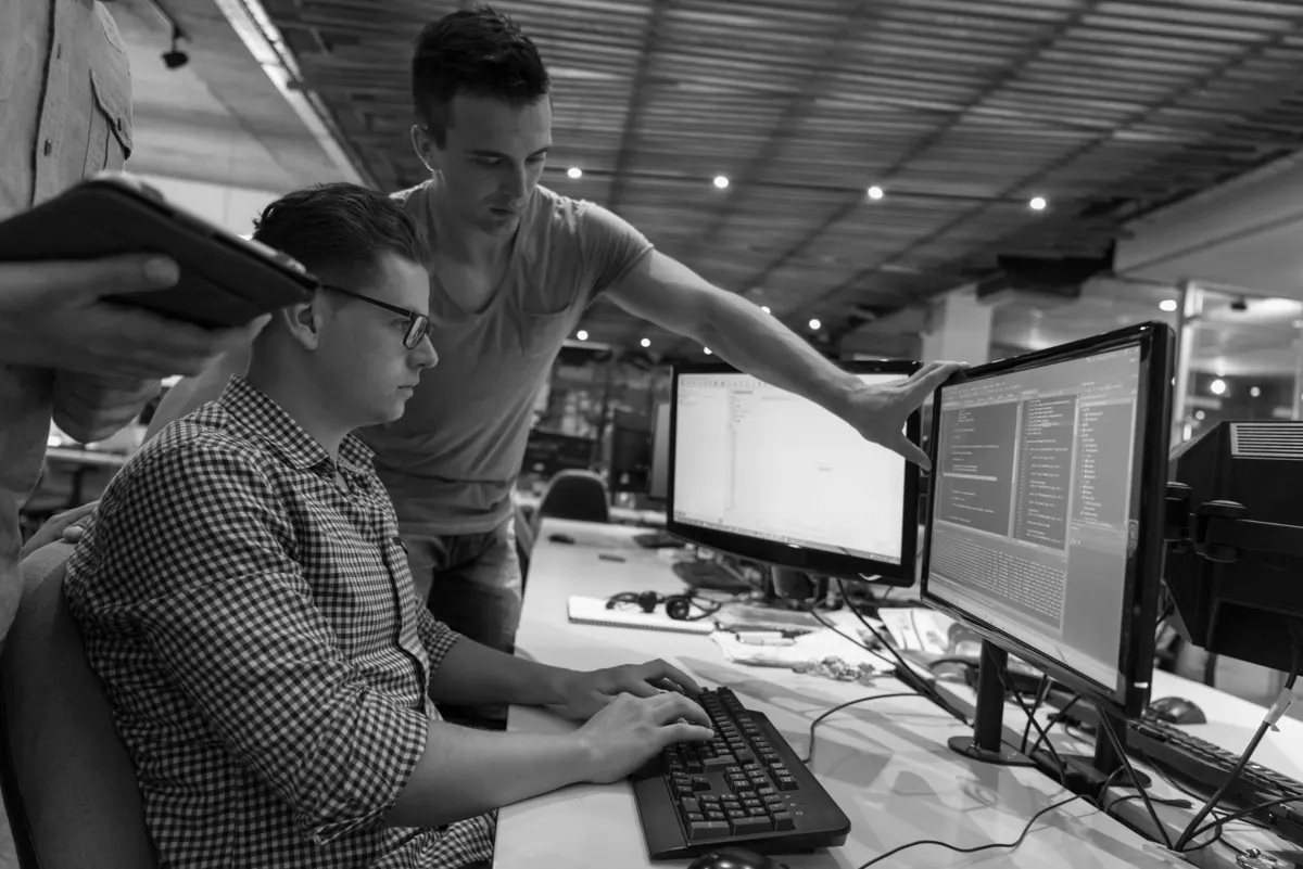 Développeurs relisant du code ensemble sur deux écrans