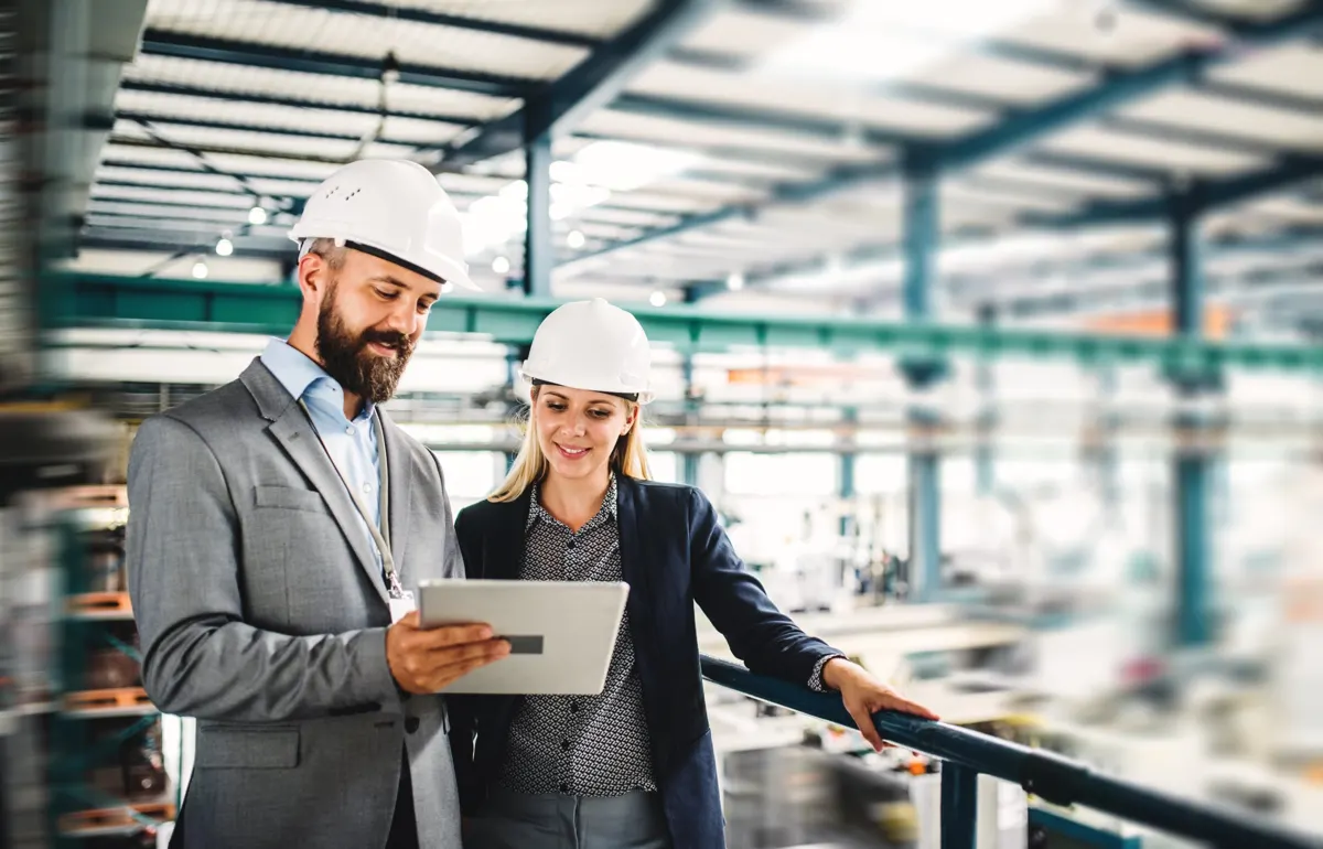 Ingénieurs en casque consultant une tablette sur un site industriel