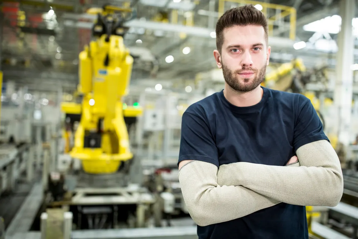 Technicien devant une ligne de production robotisée