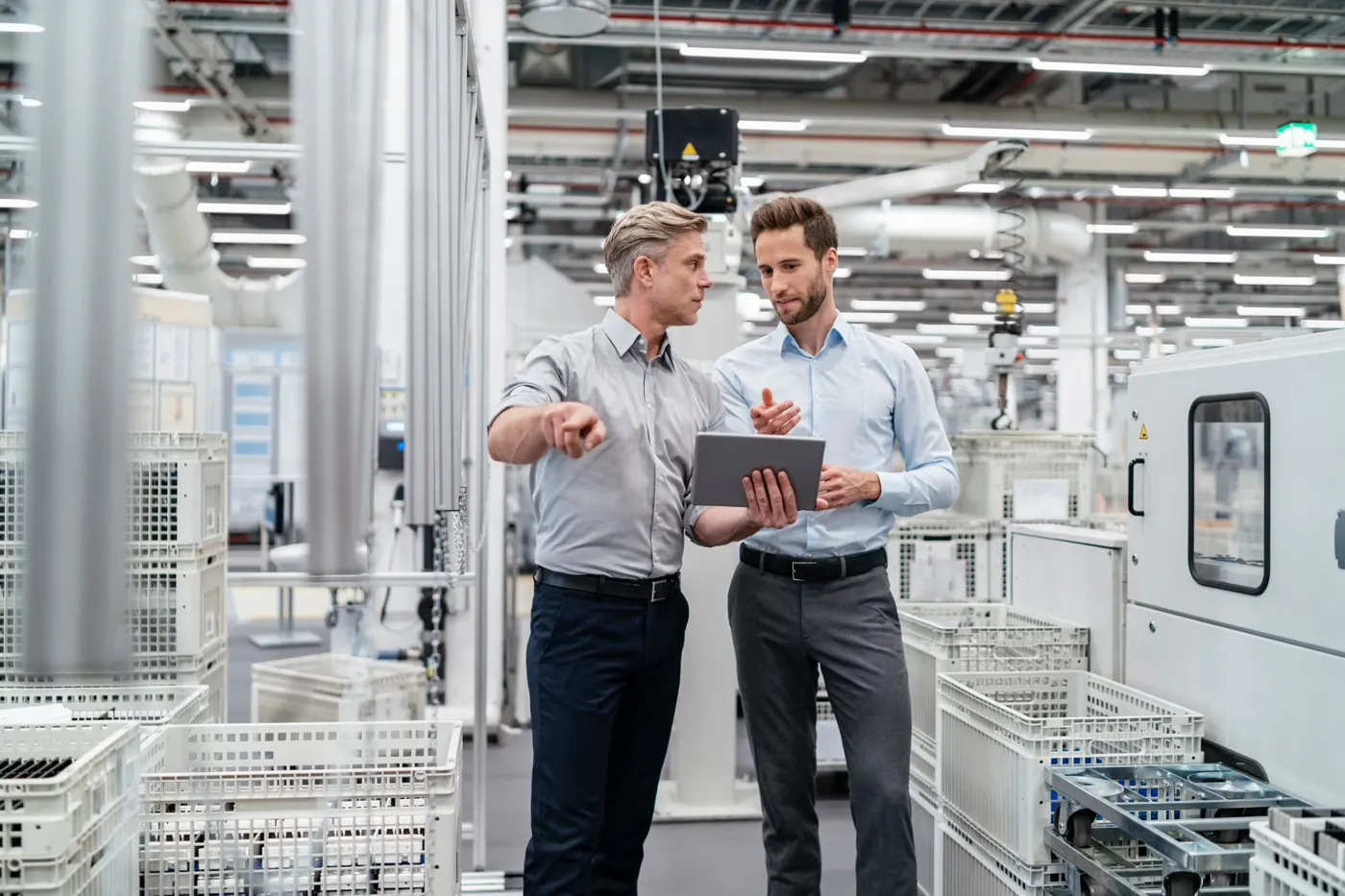 Deux responsables consultent une tablette dans une usine