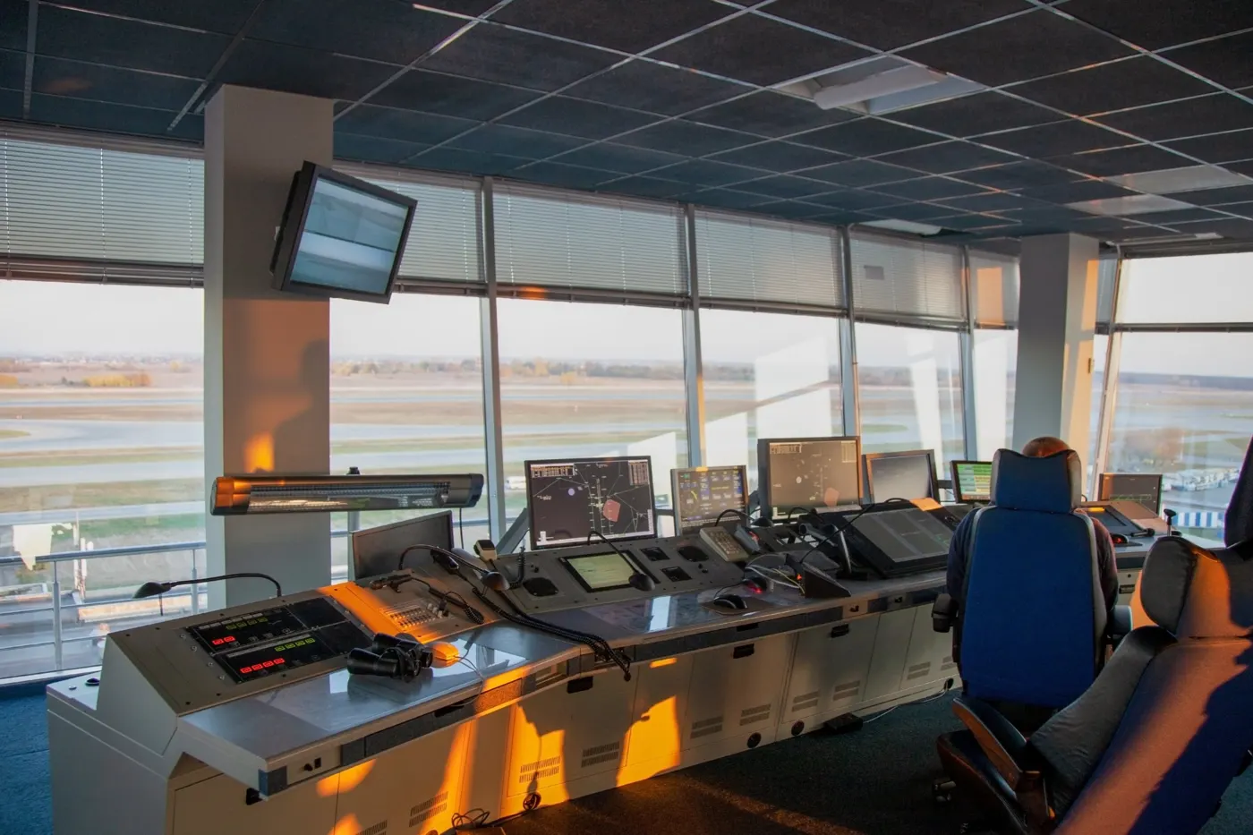 Salle de contrôle avec consoles de supervision face aux pistes